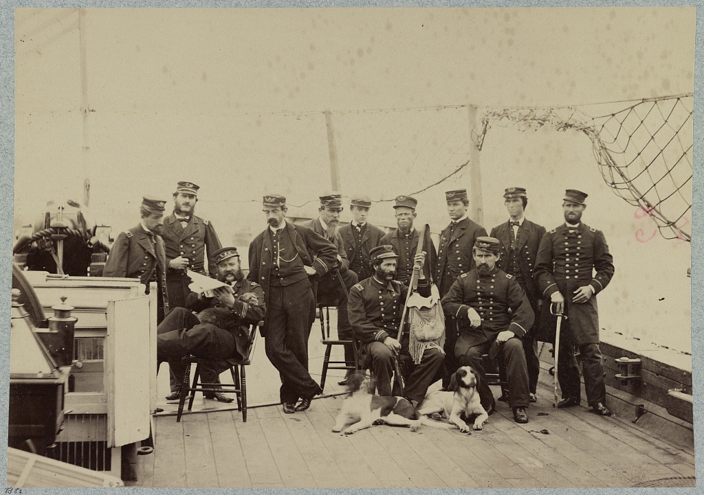Officers of the USS Miami pose on board the ship with a dog