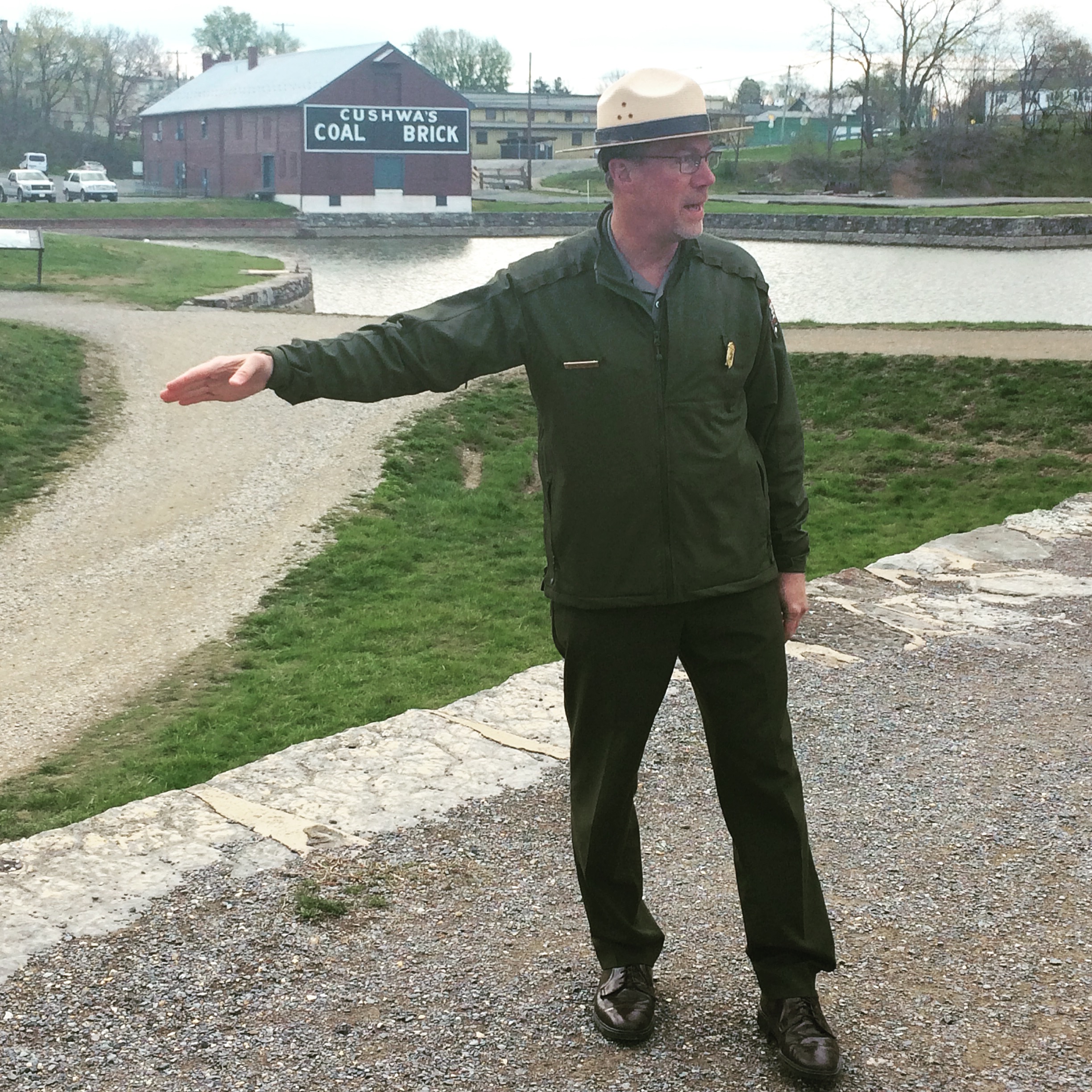 Superintendent Kevin Brandt stands on the C&O Canal Towpath by the Cushwa Basin in his NPS uniform